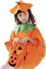 A young girl wearing a pumpkin costume and holding a pumpkin-shaped trick-or-treat bag. Produktbild-Vorschau