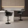 A modern kitchen with a marble backsplash and wooden cabinets, featuring two dark gray bar stools at a kitchen island. Produktbild-Vorschau