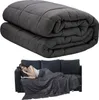 A woman is sleeping on a couch under a weighted blanket. Above, the blanket is folded. Produktbild-Vorschau