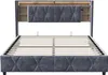 A grey upholstered bed frame with a slatted base and a headboard featuring built-in storage compartments and LED lighting. Voir les images du produit