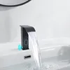 A black waterfall faucet is shown in a bathroom sink, with water flowing into the sink. Podgląd zdjęcia produktu