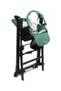 A green and black baby high chair is shown folded and standing upright against a white background. Produktbild-Vorschau