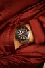 A close-up shot of a man's wrist wearing a Casio Edifice watch, with the watch partially tucked into the pocket of a red jacket. Voir les images du produit