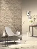 A modern living room with a stone-effect wallpaper and a stylish chair. Anteprima dell’immagine prodotto