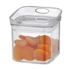 A clear plastic food storage container filled with dried apricots. Voir les images du produit