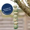 A string of bird food balls hanging from a tree branch, with a circular graphic overlay. Produktbild-Vorschau