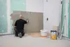A person is applying adhesive to a wall for tiling. Produktbild-Vorschau