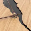 A close-up shot of a wooden clock with a black insert and metallic hands. Anteprima dell’immagine prodotto