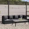 An outdoor patio scene with a black rattan sofa and coffee table. Produktbild-Vorschau