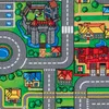 A close-up view of a colorful children's play mat depicting a town with roads, houses, a castle, and a pond. Produktbild-Vorschau