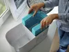 A person is inserting blue filters into a white air humidifier. Produktbild-Vorschau