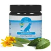 A jar of dog paw balm with some decorative flowers and leaves in the foreground. Produktbild-Vorschau
