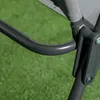 A close-up view of a gray metal chair frame and fabric seat, set against a blurred green background that appears to be grass. Náhľad obrázku produktu