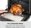 A person is holding a rotisserie spit with a cooked chicken on it, about to place it into an oven. Produktbild-Vorschau