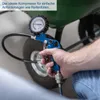 A hand holding a blue air compressor with a pressure gauge, near a tire. Produktbild-Vorschau