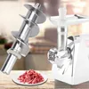 A close-up of a meat grinder auger and a pile of ground meat on a plate, with a meat grinder in the background. Náhľad obrázku produktu