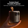 A hand holding a small, black portable projector with a leather strap. Náhled obrázku produktu