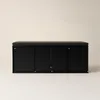 A black shoe cabinet with a padded seat on top, shown from the front against a light gray background. Náhľad obrázku produktu