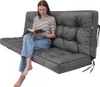 A woman is sitting on a gray cushion, reading a book. Produktbild-Vorschau