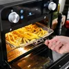 A hand is shown removing a basket of french fries from an air fryer oven. Anteprima dell’immagine prodotto