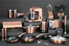 A collection of copper-colored kitchenware arranged on a dark gray surface. Anteprima dell’immagine prodotto