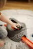 A child's hand is placing a toy tractor onto a potty training seat with a race track attached. Náhľad obrázku produktu