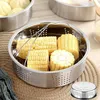 A stainless steel steamer basket filled with cut corn on the cob, placed on a woven mat. Produktbild-Vorschau