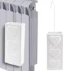 A white ceramic radiator humidifier with embossed hearts is shown hanging on a radiator. Voir les images du produit