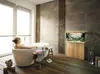 A woman is relaxing in a bathtub in a modern bathroom with wooden floors and concrete walls. An aquarium is visible in the background. Podgląd zdjęcia produktu