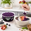 Hand greift nach Popping Boba Traube Perlen aus der Schale Podgląd zdjęcia produktu