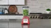 A red blender filled with green vegetables sits on a kitchen counter. Voir les images du produit