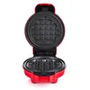 An open red waffle maker with a heart-shaped waffle plate. Produktbild-Vorschau