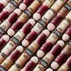 A close-up, angled view of multiple Maybelline Instant Age Rewind Concealers arranged in a repeating pattern. Podgląd zdjęcia produktu