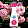 A bottle of laundry scent enhancer with roses in the background. Podgląd zdjęcia produktu