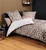 A bed with leopard print bedding, set against a slatted wooden wall. Produktbild-Vorschau