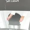 A close-up of hands adjusting the liner of a trash can, with text indicating 'Soft Closure'. Produktbild-Vorschau