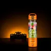 A Nutribullet McLaren edition blender bottle filled with fruit and ice, placed next to a Formula 1 car. Produktbild-Vorschau