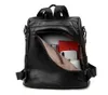 A black leather backpack is shown with its main compartment open, revealing some contents inside. Náhľad obrázku produktu