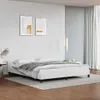 A white bed frame with a grey blanket and white pillows is shown in a bedroom setting. Náhled obrázku produktu