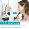 A woman is applying makeup using a lighted magnifying mirror. Produktbild-Vorschau