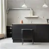 A modern kitchen with a black island and a black trash can. Produktbild-Vorschau