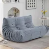 A grey sofa is placed in a living room setting with a fireplace and artwork in the background. Anteprima dell’immagine prodotto