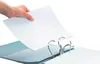 A hand is inserting a sheet of paper into a black binder with silver rings. Voir les images du produit