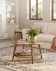 A wooden coffee table with a two-tiered design, placed on a patterned rug in a living room setting. Produktbild-Vorschau