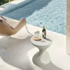 A stylish side table with a bottle of wine and two glasses by a swimming pool. Anteprima dell’immagine prodotto
