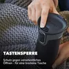 A person's hand is shown pressing a button on a black Contigo travel mug, with a textured gray blanket in the background. Produktbild-Vorschau