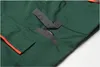 A close-up view of the details of a pair of green shorts with orange trim and gray accents. Produktbild-Vorschau