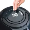 A hand is shown turning a knob on the top of a black vacuum cleaner. Produktbild-Vorschau