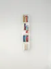 A white wall-mounted bookshelf with several books on it. Produktbild-Vorschau