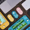 A collection of gaming accessories and devices laid out on a wooden surface. Náhľad obrázku produktu